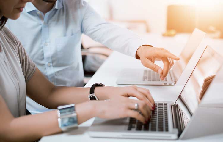 Zwei Personen arbeiten mit den Laptops