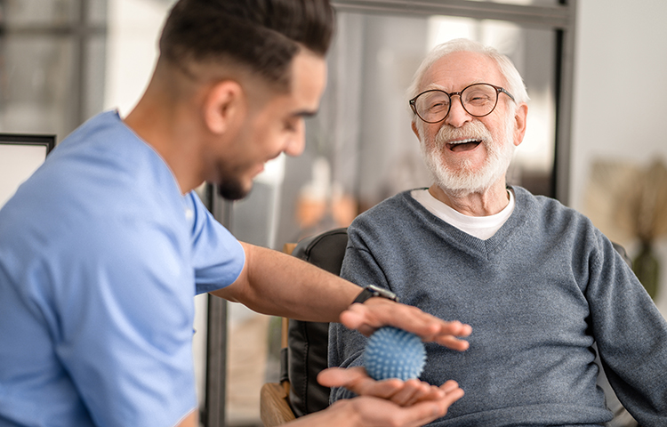 Patient having his hand massaged with a spiky massage ball