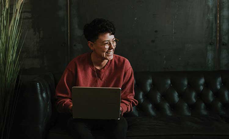 woman smiling working on a laptop